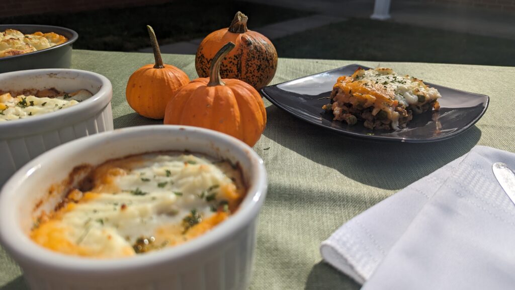 A picture of sausage shepards pie on a table with decorative pumpkins